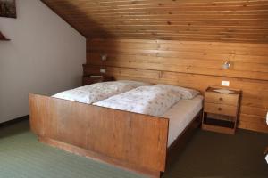 a bed in a room with a wooden wall at CIADIN APPART. in Badia