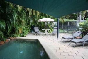 a pool with chairs and a table and an umbrella at True North B&B in Horseshoe Bay