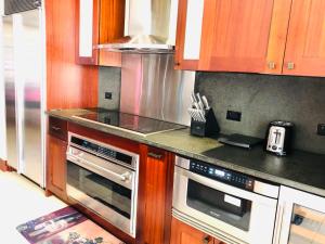 a kitchen with wooden cabinets and stainless steel appliances at Beach Villas at Ko Olina 5th floor Ocean View in Kapolei