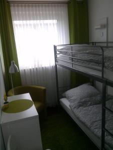 Zimmer mit einem Etagenbett, einem Schreibtisch und einem Fenster in der Unterkunft Miramar in Bremerhaven