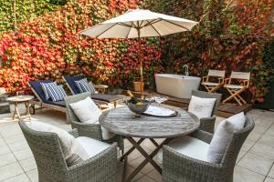 a table and chairs with an umbrella and a bath tub at Lesar Hotel Angel - Member of Hip Hotels in Ljubljana +89 photos