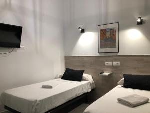 Una habitación con dos camas y un televisor de pantalla plana. en Hostal Rías Bajas, en Madrid