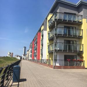 a building with balconies on the side of a sidewalk at SWANSEA BAY, MARINA & ARENA VIEW Mins to BEACH & CITY in Swansea
