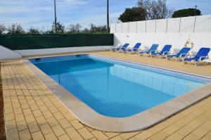 una piscina con sedie blu e una piscina di Villa Batista a Guia