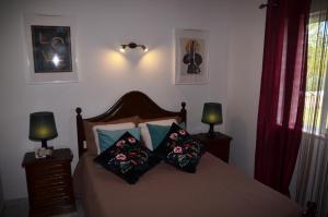una camera da letto con un letto con cuscini sopra di Villa Batista a Guia