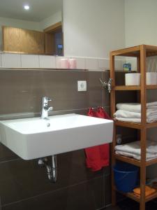 a white sink in a bathroom with a shelf at Historisches Bürgerhaus Dresden -Kulturstiftung- in Dresden