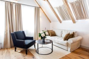 a living room with a couch and a chair and a table at Lesar Hotel Angel - Member of Hip Hotels in Ljubljana
