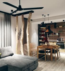 een woonkamer met een plafondventilator en een tafel bij DOR Apartment in Poiana Brasov