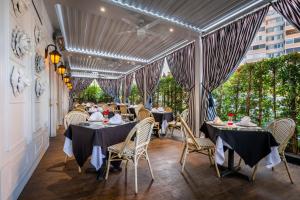 uma sala de jantar com mesas, cadeiras e cortinas em Beverly Hills Plaza Hotel & Spa em Los Angeles