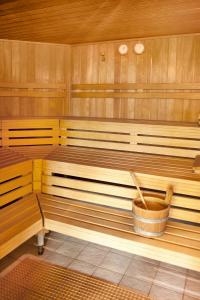 a sauna with wooden benches and a bucket at Parkhotel Matrei in Matrei am Brenner