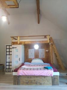 ein Schlafzimmer mit einem Holzbett in einem Zimmer in der Unterkunft Pokojíky na Větrné in Malšín