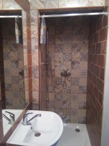 a bathroom with a white sink and a shower at Pokojíky na Větrné in Malšín