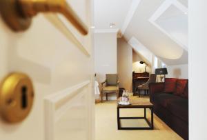 a open door to a living room with a couch and a table at Lesar Hotel Angel - Member of Hip Hotels in Ljubljana