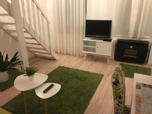 - un salon avec une télévision et un tapis vert dans l'établissement Révay 6 Apartment, à Budapest