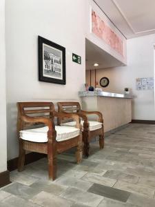 a waiting room with three chairs and a counter at Hotel Vila Real Rex in Poços de Caldas