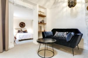 LE CELESTIN - Centre Historique - في رين: غرفة معيشة مع أريكة وطاولة وسرير