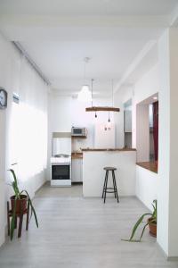 eine weiße Küche mit einer Theke und einem Tisch in der Unterkunft Kolev Apartments - Two Bedroom Cozy Central Apartment in Skopje