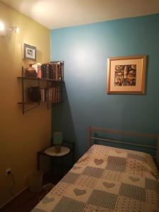 Un dormitorio con una cama y una estantería. en Single rooms in the heart of Split, en Split