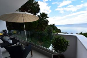 a balcony with an umbrella and a view of the ocean at Votsalo in Kavala