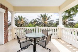 una mesa y sillas en un balcón con palmeras en Modern 2 Suites Vacation Apartment RE7659-304, en Kissimmee