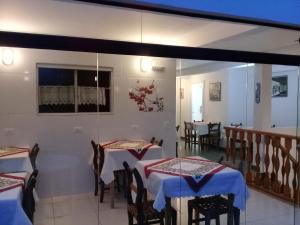 a dining room with two tables and chairs at Pousada La Sierra in Campos do Jordão +28 photos