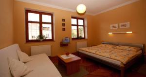 1 dormitorio con cama, sofá y ventanas en Penzion Andrej en Ružomberok