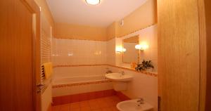 a bathroom with a sink and a toilet and a tub at Penzion Andrej in Ružomberok