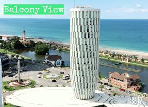 een hoge witte toren naast de oceaan bij Panorama Sea View Studio! in Batoemi