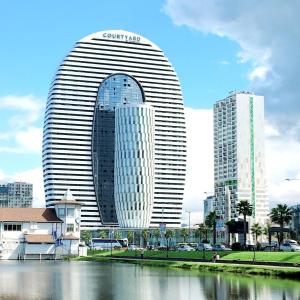 a large building next to a body of water at Panorama Sea View Studio! in Batumi