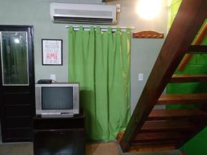 a living room with a television and a green curtain at Balcones de Molinari in Cosquín