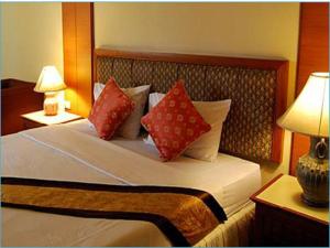 a bedroom with a large bed with red pillows at King Royal Garden Inn in Bangkok