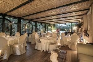 マリーナ・ディ・マッサにあるHotel Villa Maremontiの白いテーブルと椅子が備わる宴会場