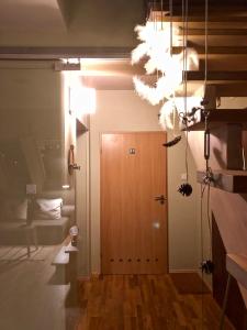 a hallway with a wooden door and white lights at Apartament Rolna CUBE27 in Poznań