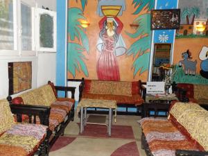 una habitación con sofás y una pintura en la pared en Bob Marley House Sherief Hotel Luxor, en Luxor