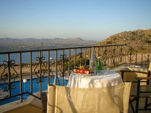 a table on a balcony with a view of the water at Panos Village in Maláxa