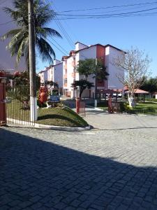 una calle con una valla y una palmera y edificios en Recanto do descanso, en Iguaba Grande