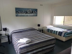 a bedroom with two beds and a window at Phillip Island Cottages in Cowes