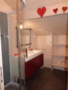 a bathroom with a sink and two hearts on the wall at La Maison Bel'Air in Gérardmer +35 photos