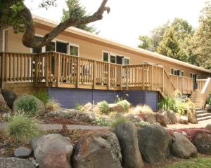 una casa con terraza y patio con rocas en Ohakune TOP 10 Holiday Park, en Ohakune