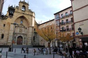 un vieux bâtiment avec une tour d'horloge dans une ville dans l'établissement El Botxito, à Bilbao