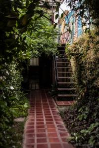 een bakstenen pad naar een gebouw met een trap bij La Casita de Salta in Salta