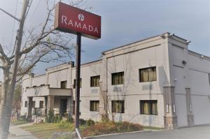 een straatbord voor een gebouw bij Ramada by Wyndham Staten Island in Staten Island