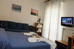 a living room with a blue couch and a tv at Hotel Villa Camilla in Varazze