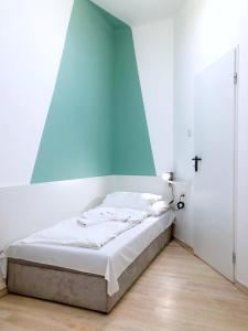 a bed in a room with a blue wall at Chesscom Guesthouse in Budapest