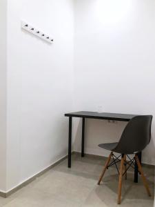 einen schwarzen Schreibtisch und einen schwarzen Stuhl in einem Zimmer in der Unterkunft Chesscom Guesthouse in Budapest