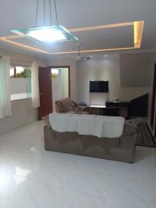 sala de estar con cama y sofá en Casa para temporada, en Cabo Frío