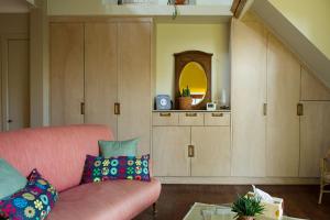 ein Wohnzimmer mit einem rosa Sofa und einem Spiegel in der Unterkunft B&B La Chambre de Plume in Brüssel