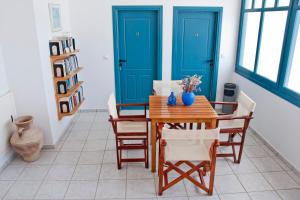 a dining room with blue doors and a table and chairs at Villa Irida in Psari Forada