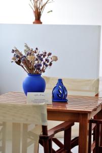 una mesa con un jarrón azul y flores en ella en Villa Irida, en Psari Forada
