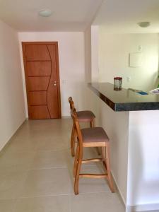 a kitchen with a wooden chair and a counter at Apartamento Le Bon Vivant Arraial do Cabo in Arraial do Cabo